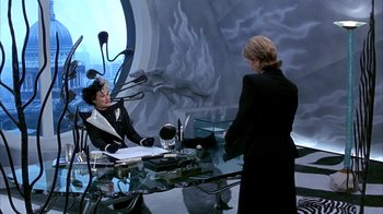 Movie still from “101 Dalmatians” (1996), directed by Stephen Herek – A woman in a black suit is talking to another woman in a black suit; Medium shot, High angle