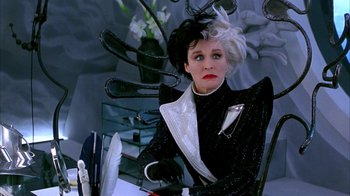 Movie still from “101 Dalmatians” (1996), directed by Stephen Herek – An older woman sitting in a chair wearing a black and white outfit; Medium shot, Over the shoulder angle