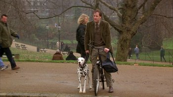 Movie still from “101 Dalmatians” (1996), directed by Stephen Herek – A man and a dalmatian dog walking in a park; Wide shot, Low angle