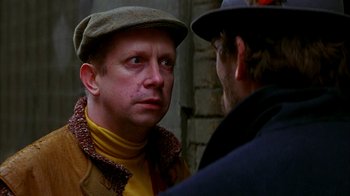 Movie still from “101 Dalmatians” (1996), directed by Stephen Herek – A man wearing a hat talking to another man wearing a hat; Close Up shot, Over the shoulder angle