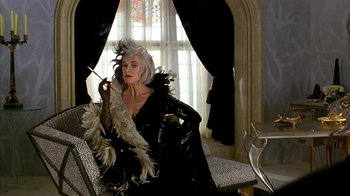 Movie still from “101 Dalmatians” (1996), directed by Stephen Herek – A woman dressed in a black costume with feathers; Medium shot, Over the shoulder angle