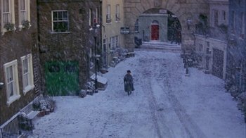 Movie still from “101 Dalmatians” (1996), directed by Stephen Herek – A man walking down a snowy street in the snow; Extreme Wide shot, High angle