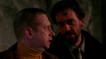 Movie still from “101 Dalmatians” (1996), directed by Stephen Herek – Two men in suits and ties looking at each other; Close Up shot, Over the shoulder angle