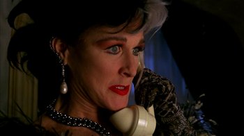 Movie still from “101 Dalmatians” (1996), directed by Stephen Herek – A woman talking on a phone while wearing pearls; Close Up shot, Low angle