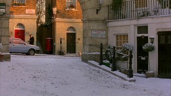 Movie still from “101 Dalmatians” (1996), directed by Stephen Herek – A street corner with a parking meter and a street sign; Extreme Wide shot, High angle
