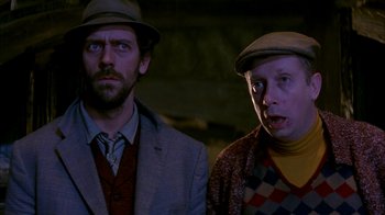 Movie still from “101 Dalmatians” (1996), directed by Stephen Herek – Two men wearing hats and a suit stand next to each other; Close Up shot, Low angle