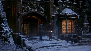 Movie still from “101 Dalmatians” (1996), directed by Stephen Herek – Two men are standing on the steps in the snow; Wide shot, High angle