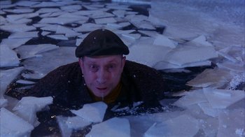 Movie still from “101 Dalmatians” (1996), directed by Stephen Herek – A man wearing a hat is swimming in the water; Medium shot, High angle