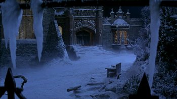 Movie still from “101 Dalmatians” (1996), directed by Stephen Herek – A bench sitting in front of a building covered in snow; Extreme Wide shot, High angle