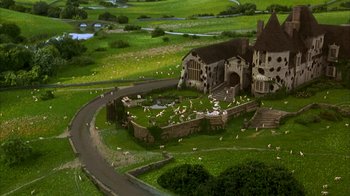 Movie still from “101 Dalmatians” (1996), directed by Stephen Herek – An aerial view of a house with sheep grazing in the yard; Extreme Wide shot, High angle