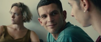 Movie still from “120 BPM” (2017), directed by Robin Campillo – A person smiling for the camera; Close Up shot, Over the shoulder angle