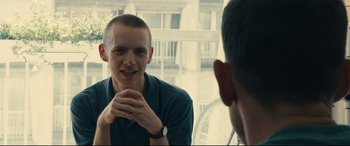 Movie still from “120 BPM” (2017), directed by Robin Campillo – A man sitting in front of another man in front of a window; Close Up shot, Over the shoulder angle