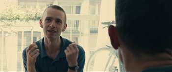 Movie still from “120 BPM” (2017), directed by Robin Campillo – A man sitting in front of another man in front of a bicycle; Close Up shot, Over the shoulder angle