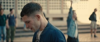 Movie still from “120 BPM” (2017), directed by Robin Campillo – A young man is looking down while standing on a sidewalk; Close Up shot, Over the shoulder angle