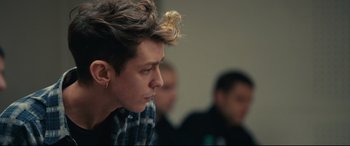 Movie still from “120 BPM” (2017), directed by Robin Campillo – A man with a messy hair style looks to his left; Close Up shot, Over the shoulder angle