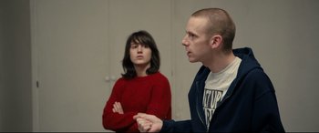 Movie still from “120 BPM” (2017), directed by Robin Campillo – A man and a woman are sitting in front of each other; Medium shot, Over the shoulder angle