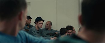 Movie still from “120 BPM” (2017), directed by Robin Campillo – A group of men sitting in a room together; Medium shot, Over the shoulder angle