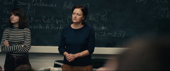 Movie still from “120 BPM” (2017), directed by Robin Campillo – A woman standing in front of a chalkboard; Medium shot, Over the shoulder angle