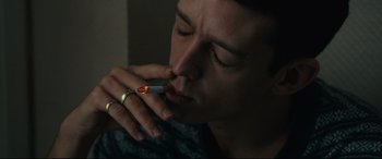 Movie still from “120 BPM” (2017), directed by Robin Campillo – A man smoking a cigarette with a ring on his finger; Close Up shot, Over the shoulder angle