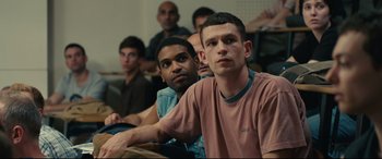 Movie still from “120 BPM” (2017), directed by Robin Campillo – A group of people sitting in a room together; Medium shot, Over the shoulder angle