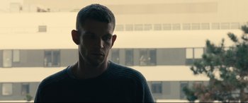 A man in a black shirt is looking at the camera