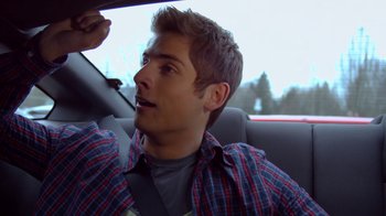 Movie still from “16 Wishes” (2010), directed by Peter DeLuise – A man sitting in the passenger seat of a car; Close Up shot, Over the shoulder angle