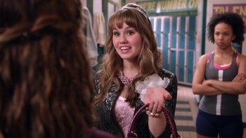 Movie still from “16 Wishes” (2010), directed by Peter DeLuise – A woman in a black and pink dress holding a purple purse; Medium shot, Over the shoulder angle