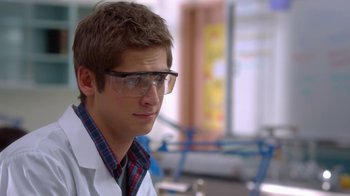 Movie still from “16 Wishes” (2010), directed by Peter DeLuise – A man in a lab coat and glasses looking to his left; Close Up shot, Over the shoulder angle