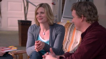 Movie still from “16 Wishes” (2010), directed by Peter DeLuise – A woman sitting next to a man on a couch; Medium shot, Over the shoulder angle