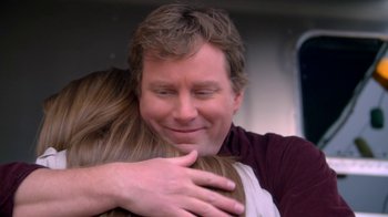 Movie still from “16 Wishes” (2010), directed by Peter DeLuise – A man hugging a woman in front of a window; Close Up shot, Over the shoulder angle