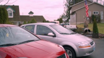 Movie still from “16 Wishes” (2010), directed by Peter DeLuise – A couple of cars parked in a parking lot next to each other; Medium shot, Over the shoulder angle