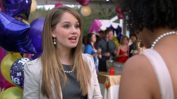 Movie still from “16 Wishes” (2010), directed by Peter DeLuise – A woman is talking to a crowd at a party; Close Up shot, Over the shoulder angle