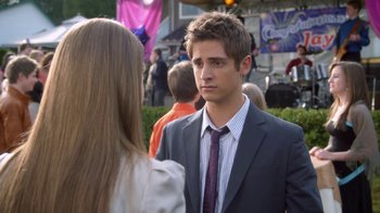 Movie still from “16 Wishes” (2010), directed by Peter DeLuise – A man in a suit and tie talking to a woman in a suit; Close Up shot, Over the shoulder angle