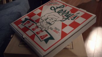 Movie still from “16 Wishes” (2010), directed by Peter DeLuise – A box of pizza sitting on top of a wooden table; Extreme Close Up shot, High angle