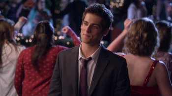 Movie still from “16 Wishes” (2010), directed by Peter DeLuise – A man in a suit and tie in front of a crowd of onlookers; Medium shot, Over the shoulder angle
