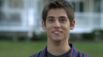 Movie still from “16 Wishes” (2010), directed by Peter DeLuise – A young man smiling for the camera; Close Up shot, Over the shoulder angle