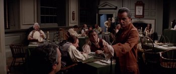 Movie still from “1776” (1972), directed by Peter H. Hunt – A group of people sitting around a table; Medium shot, Over the shoulder angle
