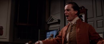 Movie still from “1776” (1972), directed by Peter H. Hunt – A man in a brown jacket is singing; Medium shot, Low angle