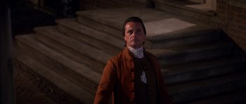 Movie still from “1776” (1972), directed by Peter H. Hunt – A man standing in front of some stairs; Medium shot, Low angle