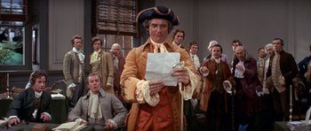 Movie still from “1776” (1972), directed by Peter H. Hunt – A group of men in period clothing holding papers; Medium shot, Low angle