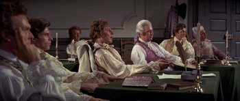 Movie still from “1776” (1972), directed by Peter H. Hunt – A group of people sitting around a table; Medium shot, High angle