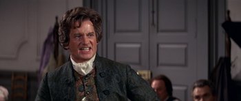 Movie still from “1776” (1972), directed by Peter H. Hunt – A person wearing a suit and tie; Medium shot, Over the shoulder angle