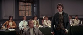 Movie still from “1776” (1972), directed by Peter H. Hunt – A group of people sitting in a room; Medium shot, Over the shoulder angle