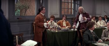 Movie still from “1776” (1972), directed by Peter H. Hunt – A group of people sitting around a table; Wide shot, High angle