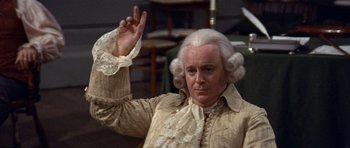 Movie still from “1776” (1972), directed by Peter H. Hunt – An older man in a white wig and wig; Medium shot, High angle