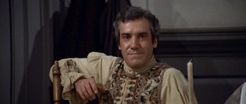 Movie still from “1776” (1972), directed by Peter H. Hunt – A person sitting in a chair wearing a vest; Medium shot, High angle