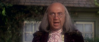 Movie still from “1776” (1972), directed by Peter H. Hunt – A bald man in a wig and glasses; Close Up shot, Low angle