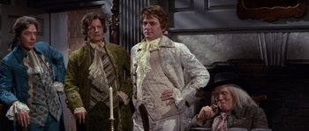 Movie still from “1776” (1972), directed by Peter H. Hunt – A man in a white jacket standing next to a woman in a white dress; Medium shot, High angle
