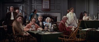 Movie still from “1776” (1972), directed by Peter H. Hunt – A group of people sitting around a table; Wide shot, High angle