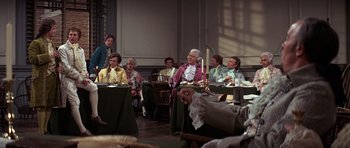 Movie still from “1776” (1972), directed by Peter H. Hunt – A group of people sitting around a table; Wide shot, Over the shoulder angle